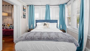 A neatly arranged bedroom with a large bed, a nightstand, and a window with curtains. - Quiet 6BR Family Getaway Near Beach + Casinos (Atlantic City)