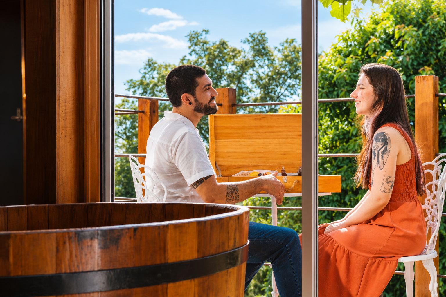 A couple seated at a wooden table with a view of greenery outside.