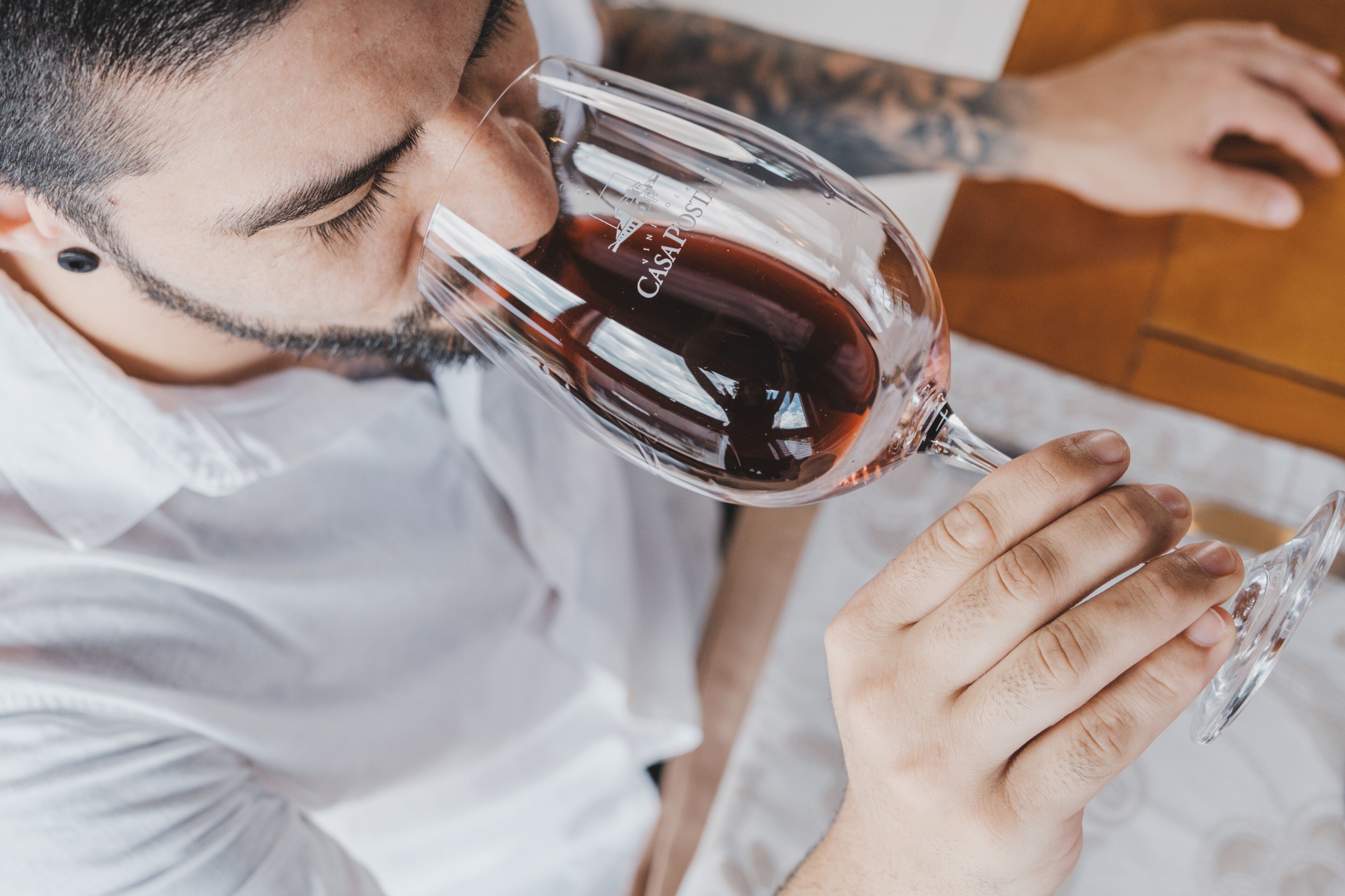 Una persona sosteniendo una copa de vino con una etiqueta que dice "CASAPOST".