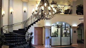 A grand staircase with a black metal railing leading to a second floor.