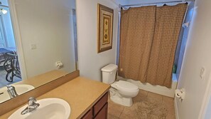 Een bad/douchecombinatie, een haardroger, handdoeken, zeep