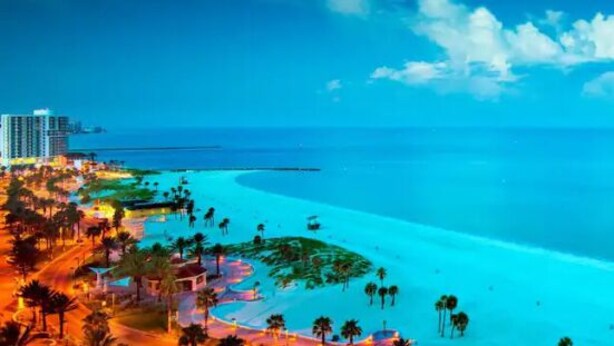 A coastal resort with a beach, palm trees, and a large building in the background. - Most Comfortable Bed • Pet Friendly • 2 Baths • 4 Beds • 4mi to Clearwater Beach (Clearwater)
