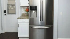 A stainless steel refrigerator in a kitchen with white cabinets and a wooden floor. - Most Comfortable Bed • Pet Friendly • 2 Baths • 4 Beds • 4mi to Clearwater Beach (Clearwater)