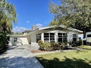 Stroll out to the inviting front porch, surrounded by lush greenery and large windows.