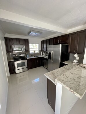 Enjoy cooking in this well-equipped kitchen with a double oven, microwave, refrigerator, and dishwasher.