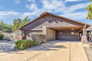 A single-story house with a sloped roof, a stone chimney, and a covered garage.