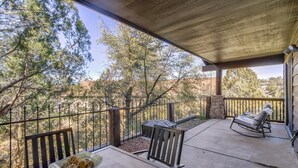 Un patio al aire libre con una mesa, sillas y una parrilla.