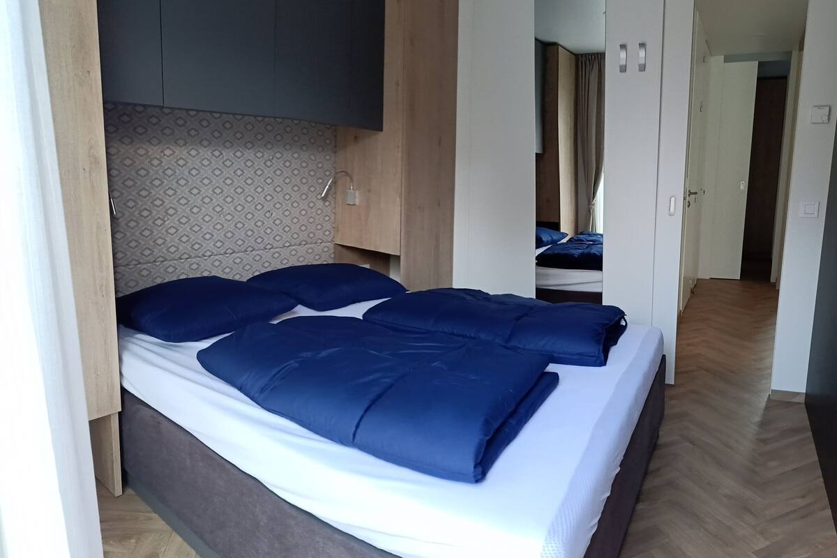 Un dormitorio con cama, armario y espejo.