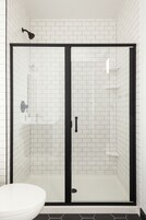 Bañera con ducha, artículos de tocador de diseñador, secador de pelo