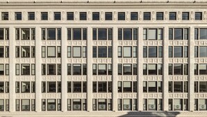 A multi-story building with a symmetrical facade, featuring a grid of windows and decorative moldings. - ROOST Cleveland (Cleveland)