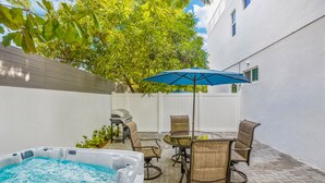 A backyard with a hot tub, patio furniture, and a barbecue grill. - UP TO 12 GUESTS! Modern house near Wynwood (Miami)