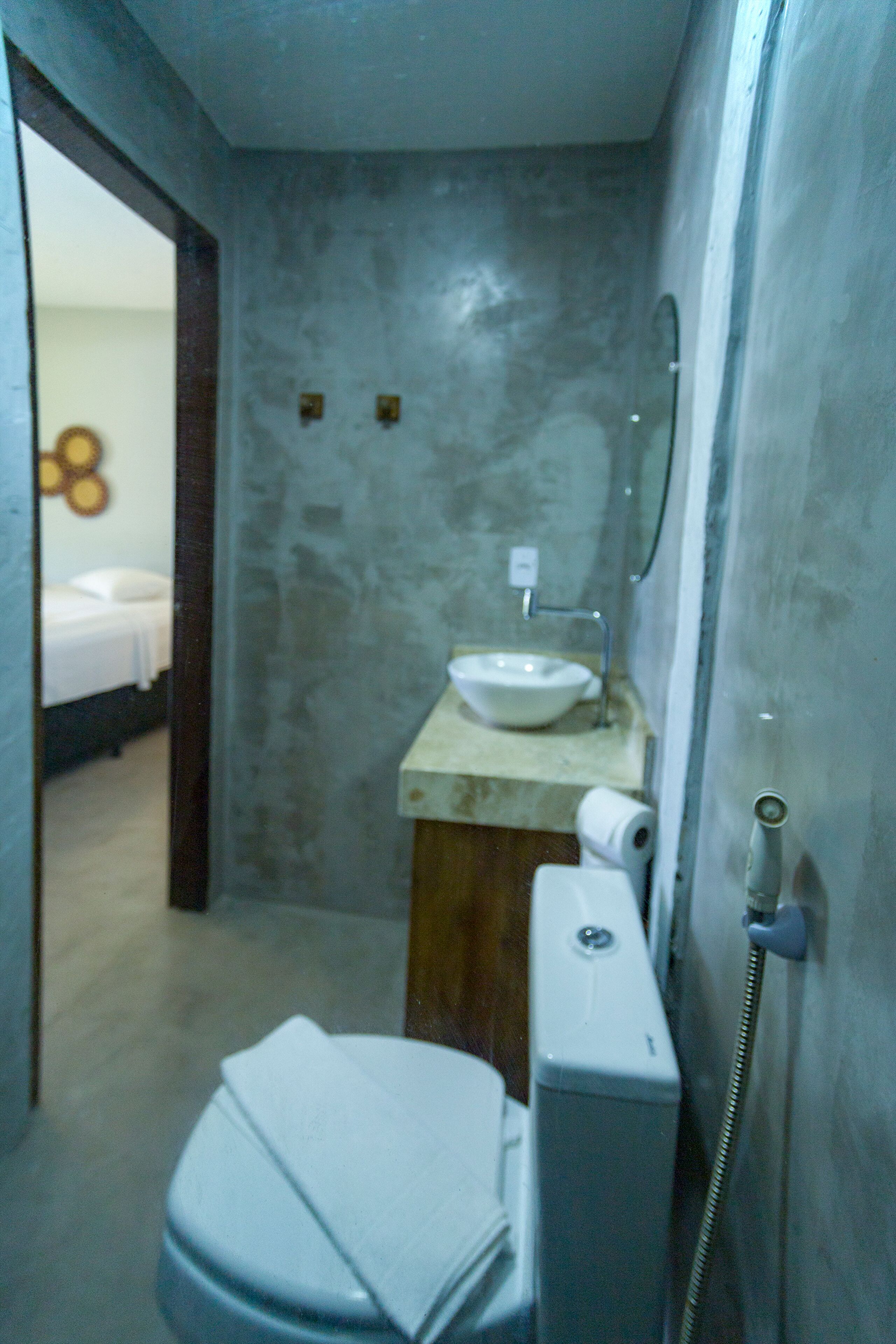 Casa de banho compacta com sanita, lavatório e chuveiro.