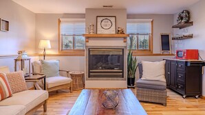 A cozy living room with a fireplace, comfortable seating, and a coffee table. - Family and big group 14 Guests 11 beds 5 baths (Hudsonville)