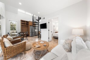 Un vaste espace de vie comprenant une cuisine moderne, un coin repas et un salon confortable.