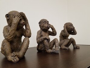 Drei hölzerne Skulpturen sitzender Personen.