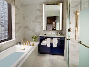 Une salle de bain moderne Ă©quipĂ©e dâune baignoire, dâun meuble-lavabo, dâun miroir et dâune douche.
