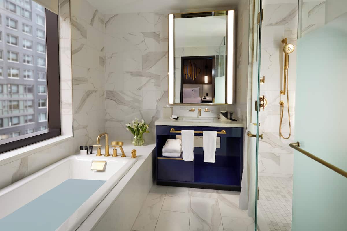 Un baño moderno con bañera, tocador con espejo y zona de ducha.
