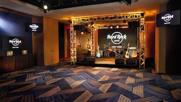 Camera di un Hard Rock Hotel con un palco, strumenti musicali e una moquette fantasia.