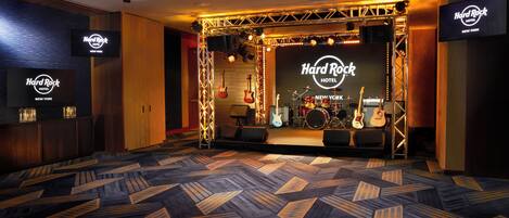 A Hard Rock Hotel room with a stage, musical instruments, and a patterned carpet.