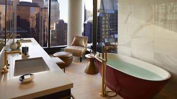 Relax in a spacious bathroom with a bathtub, sink area, and seating area.