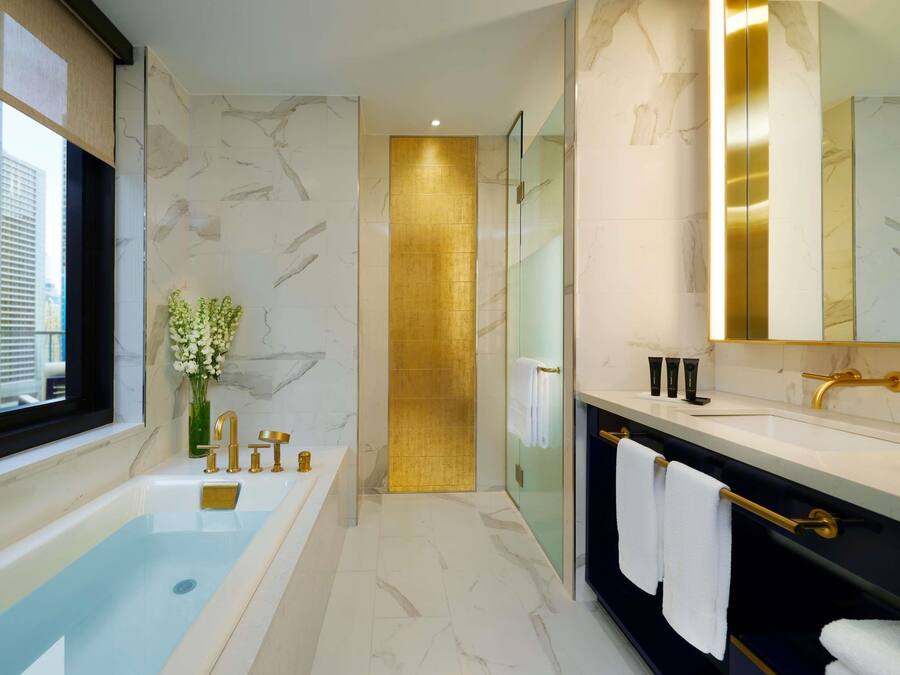A modern bathroom with a bathtub, a vanity with a mirror, and a shower area.