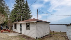A small, single-story cabin with a sloped roof, a front door, and a window on the right side. - Deluxe Beachfront Villa 3 Bedroom, sleeps 10 (Mar)