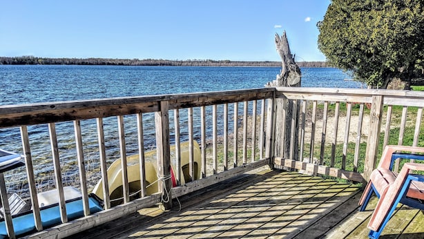 A wooden deck with a view of a lake and boats.