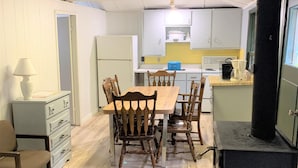 A cozy kitchen with a dining table, chairs, a stove, and cabinets. - Deluxe Beachfront Villa 3 Bedroom, sleeps 10 (Mar)