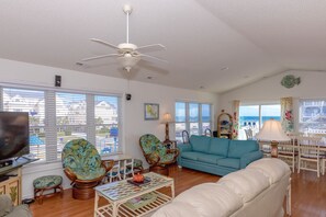 A living room with a ceiling fan, a television, a sofa, and a coffee table.