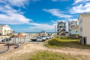 A beachfront property with multiple buildings, a parking area, and a sandy beach.