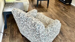 Una sala de estar con sofá, reposapiés, mesa de centro y mueble para TV con televisor de pantalla plana y señal de Wi-Fi.
