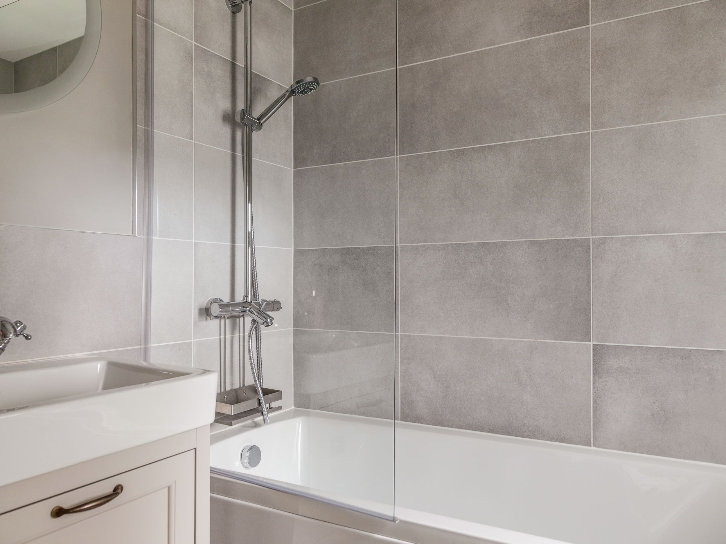 Une salle de bain moderne équipée d’une baignoire, d’une douche et d’un lavabo.