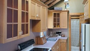 Eine Küche mit Holzausstattung, einem Herd, einer Spüle und einem Kühlschrank.