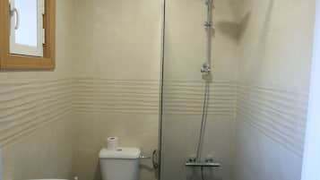Een douche, handdoeken, zeep, toiletpapier