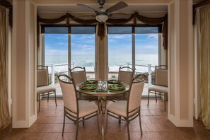 A dining area with a table set for four, overlooking the ocean. - Tower Four - Oceanfront Historic Missile Tower - 3 BR / 2.5 BATH (Surf City)