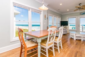 A dining area with a view of the beach, a ceiling fan, and a television. - Vitamin Sea - Oceanfront, 5 BR Home in Surf City - Elevator! (Surf City)