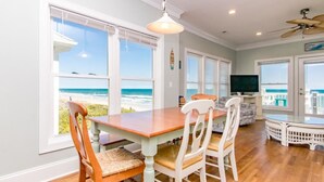 A dining area with a view of the beach, a television, and a ceiling fan. - Vitamin Sea - Oceanfront, 5 BR Home in Surf City - Elevator! (Surf City)