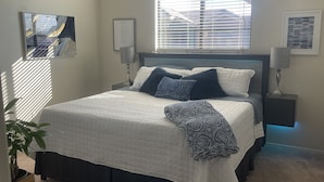 A bedroom with a bed, bedside tables, lamps, and a window with blinds. - Phoenix Oasis - Ah! Ahwatukee! (Phoenix)