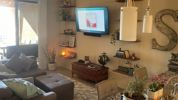 A living room with a television, a large 'S' wall decoration, a globe, and a fireplace. - Phoenix Oasis - Ah! Ahwatukee! (Phoenix)