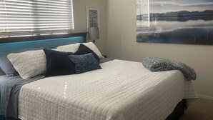 A neatly made bed with a quilted white cover, several pillows, and a patterned throw blanket. - Phoenix Oasis - Ah! Ahwatukee! (Phoenix)