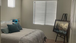 A bedroom with a bed, a painting on an easel, and a ceiling fan. - Phoenix Oasis - Ah! Ahwatukee! (Phoenix)