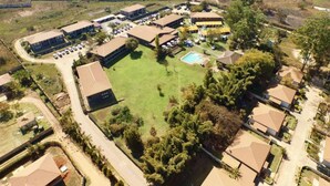An aerial view of a residential area with multiple houses, a swimming pool, and a large open grassy area. - The Royal Solwezi Hotel (Solwezi)