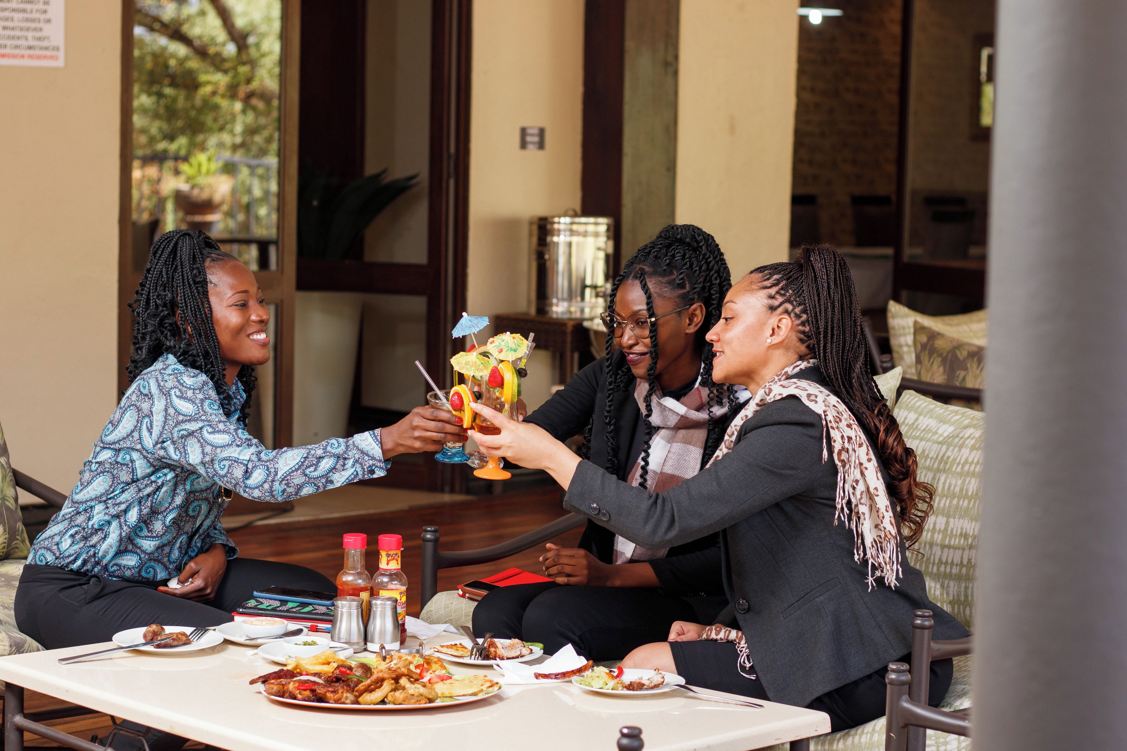 Un groupe de personnes est assis autour d’une table, devant des assiettes remplies de nourriture, des verres et des condiments.