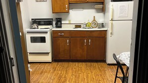 A compact kitchen with wooden cabinets, a white refrigerator, a microwave, a stove, and a sink. - Lakeview Scenic Cabin sleep 4 (Mar)