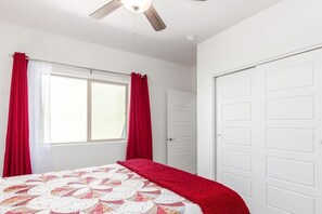 A bedroom with a bed, a window with curtains, a door, and a ceiling fan. - Charming two-bedroom in Tubac Golf Resort (Tubac)
