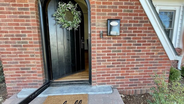 A brick house with a black door, a mailbox, and a doormat with "hello" written on it. - Cozy Double King Suite Bungalow (Great Bend)