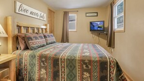 A bedroom with a bed, a television, a window, and a wall with motivational quotes. - The Love Shack (Hocking Hills Area) (Rockbridge)