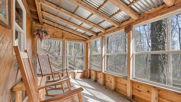 A wooden cabin with large windows, wooden furniture, and a rustic interior. - The Love Shack (Hocking Hills Area) (Rockbridge)