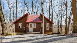 A wooden cabin with a red roof, surrounded by trees. - Cliff's Edge (Hocking Hills Area) (Amanda)