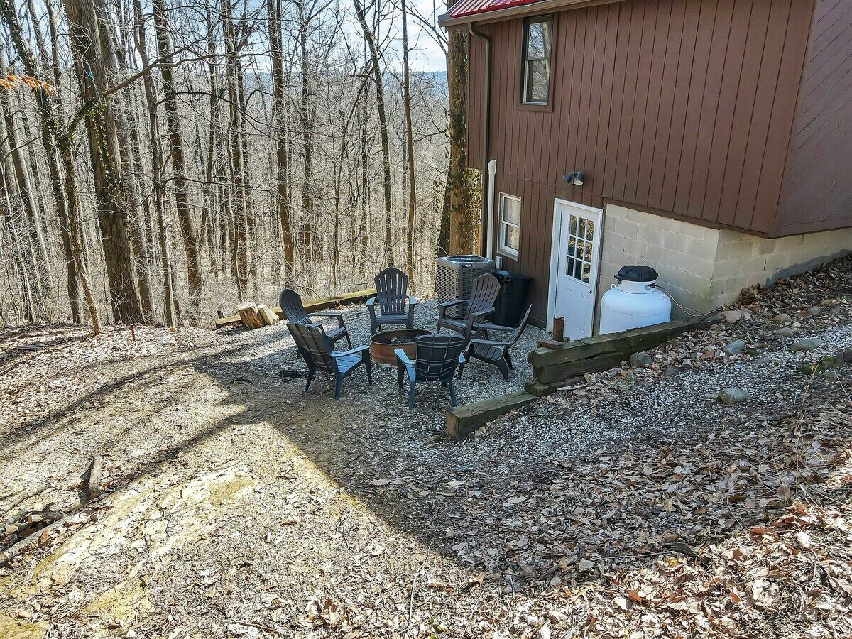 A cabin with a fire pit and outdoor seating area.